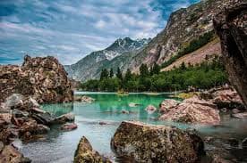 Colorful alpine lake surrounded by pine forest and mountains in Naltar Valley, Gilgit-Baltistan